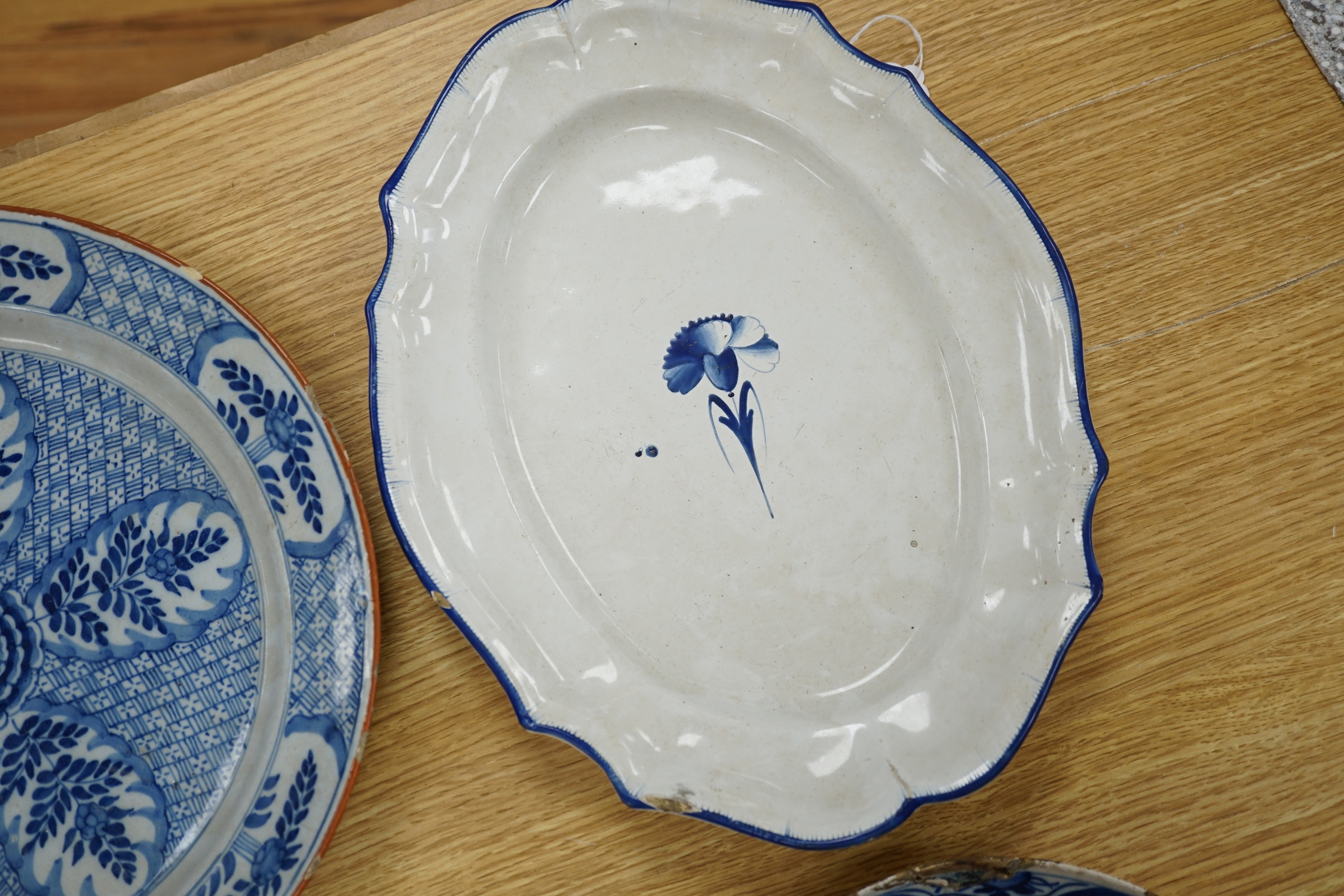 Four various continental delftware dishes, 18th and 19th century, largest 31cm diameter. Condition - various cracks and chipping to edges
